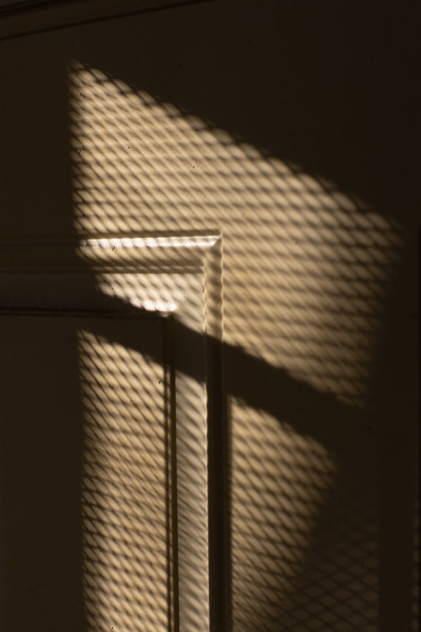 beige wall with window net shadows